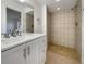 Modern bathroom featuring double sinks and a step-in shower with tile surround at 3527 65Th Avenue E Cir, Sarasota, FL 34243