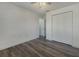 A bright bedroom with wood-look floors, neutral walls, ceiling fan, and a double-door closet for ample storage at 3527 65Th Avenue E Cir, Sarasota, FL 34243