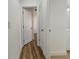 Hallway with hardwood flooring and an open door at 3527 65Th Avenue E Cir, Sarasota, FL 34243