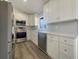 Modern kitchen featuring stainless steel appliances, white cabinets, and a stylish backsplash at 3527 65Th Avenue E Cir, Sarasota, FL 34243