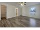 A bright main bedroom boasts wood-look floors, neutral walls, and a closet for storage with an attached bathroom at 3527 65Th Avenue E Cir, Sarasota, FL 34243