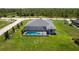 Aerial view of a beautiful home with a screened-in pool and surrounded by lush green grass at 291 Rotonda S Blvd, Rotonda West, FL 33947