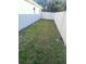 Side yard features white fencing, partial grass and gate at 3307 W Ballast Point Blvd, Tampa, FL 33611