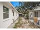 A white single-story home with an access road to the detached garage with white rock covering at 3307 W Ballast Point Blvd, Tampa, FL 33611