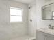Bathroom with marble tile shower, window and modern vanity at 3307 W Ballast Point Blvd, Tampa, FL 33611