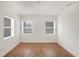 Bedroom with white walls, hardwood floors, and natural light from two windows at 3307 W Ballast Point Blvd, Tampa, FL 33611
