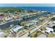 Aerial view of a waterfront home with a canal, lush trees, and well-maintained landscaping at 149 Roselle Ct, Port Charlotte, FL 33952