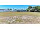 Expansive backyard featuring a well-maintained lawn and mature palm trees offers ample space for outdoor activities at 149 Roselle Ct, Port Charlotte, FL 33952