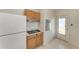 Efficient kitchen with white refrigerator, stove, wood cabinets, and convenient layout at 149 Roselle Ct, Port Charlotte, FL 33952