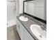 Bathroom featuring a dual sink vanity with granite countertops and a walk-in shower at 15729 Fort Island Pl, Sun City Center, FL 33573