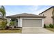 Charming one-story home featuring a two-car garage, landscaped yard, and well-maintained lawn at 15729 Fort Island Pl, Sun City Center, FL 33573