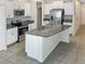 Modern kitchen with white cabinets, granite counters, stainless steel appliances, and a spacious center island at 15729 Fort Island Pl, Sun City Center, FL 33573