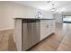View of kitchen island with stainless steel dishwasher and granite countertop at 15729 Fort Island Pl, Sun City Center, FL 33573