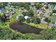 Aerial view of a neighborhood featuring a pond, tree-lined streets and well-maintained homes at 1937 N Highland Ave, Clearwater, FL 33755
