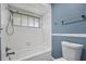This renovated bathroom has blue walls, a shower/tub combo, and a toilet at 1937 N Highland Ave, Clearwater, FL 33755