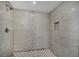 Walk-in shower displaying elegant tile work, including a decorative strip and patterned floor at 1937 N Highland Ave, Clearwater, FL 33755