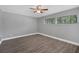 This bedroom features wood-look floors, neutral walls, a window with blinds, and a ceiling fan at 1937 N Highland Ave, Clearwater, FL 33755