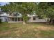 Exterior showing the screened-in porch addition, chimney, and verdant lawn at 1937 N Highland Ave, Clearwater, FL 33755
