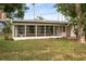 Home exterior featuring an enclosed sunroom with several windows and a well-manicured lawn at 1937 N Highland Ave, Clearwater, FL 33755