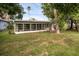 View of the home's exterior with the screened-in porch addition and spacious backyard at 1937 N Highland Ave, Clearwater, FL 33755