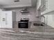 This updated kitchen features stainless appliances, granite countertops, subway tile backsplash, and shaker cabinets at 1937 N Highland Ave, Clearwater, FL 33755