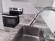 A close-up showcases the kitchen's granite countertops, stainless steel sink, and subway tile backsplash at 1937 N Highland Ave, Clearwater, FL 33755