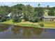 Picturesque view of a pond reflecting the nearby homes and lush green trees at 1937 N Highland Ave, Clearwater, FL 33755