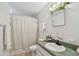 Cozy bathroom featuring a vanity with a green countertop, decorative greenery, and neutral shower curtain at 204 Ne Jefferson N Cir, St Petersburg, FL 33702