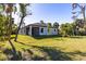 A view of the backyard with lush green lawn and tropical landscaping at 4313 Appleton Ter, North Port, FL 34286