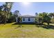 The home has a spacious yard with lush green grass and tropical landscaping at 4313 Appleton Ter, North Port, FL 34286