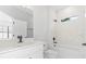 A bathroom features marble tiling in the shower, a window, and a white vanity with black hardware at 4313 Appleton Ter, North Port, FL 34286