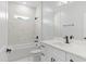 Elegant bathroom with white vanity, marble tile, tub, and shower combination at 4313 Appleton Ter, North Port, FL 34286