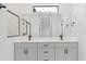 Bright bathroom with double vanity, gray cabinets, modern fixtures, and large mirror at 4313 Appleton Ter, North Port, FL 34286