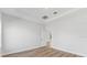 Bright bedroom with hardwood flooring, recessed lighting, tray ceiling, and a door to another room at 4313 Appleton Ter, North Port, FL 34286