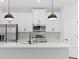 Modern kitchen with stainless steel appliances, sleek white cabinets, and a center island with a sink at 4313 Appleton Ter, North Port, FL 34286