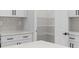 This kitchen features white cabinets, quartz countertops, tile backsplash, and a walk-in pantry at 4313 Appleton Ter, North Port, FL 34286