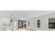 An open concept living room and kitchen area with modern lighting and floor to ceiling windows creates a bright space at 4313 Appleton Ter, North Port, FL 34286