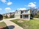 Two-story home features a neutral exterior, attached two-car garage, a yard and common sidewalk at 10019 Warm Stone St, Thonotosassa, FL 33592