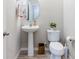 Cozy powder room featuring a pedestal sink, toilet, oval mirror, and decorative accents at 13001 Pennybrook Dr, Riverview, FL 33579