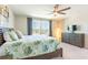 Bright bedroom features a ceiling fan, a dresser, and a large window with neighborhood views at 13001 Pennybrook Dr, Riverview, FL 33579