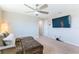 Comfortable loft area featuring a cozy couch, modern ceiling fan and mounted TV at 13001 Pennybrook Dr, Riverview, FL 33579