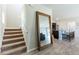 Bright, carpeted staircase with a large mirror and view of the kitchen and living area at 13001 Pennybrook Dr, Riverview, FL 33579