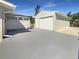 Detached garage featuring a paved driveway, clean exterior and a fenced outdoor shower at 1540 David Pl, Englewood, FL 34223