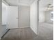 Hallway with carpet leading to a bedroom with neutral walls and ceiling fan, creating a cozy transition space at 1540 David Pl, Englewood, FL 34223