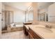 Elegant bathroom featuring double sinks, a soaking tub, and a glass-enclosed shower at 19012 Quarry Badger Rd, Land O Lakes, FL 34638