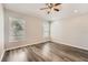 Cozy bedroom with hardwood floors and two large windows providing ample light at 19012 Quarry Badger Rd, Land O Lakes, FL 34638
