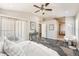 Bright primary bedroom featuring a ceiling fan, en-suite bathroom, and private patio access at 19012 Quarry Badger Rd, Land O Lakes, FL 34638