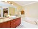 Bathroom features a modern vanity with sink, a large mirror, and a separate soaking tub at 5769 E Price Blvd, North Port, FL 34288