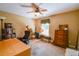 This bedroom features soft carpet, a ceiling fan, and ample space for work and hobbies at 5769 E Price Blvd, North Port, FL 34288