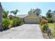 Charming home exterior showcasing a well-maintained lawn and a 2-car garage at 5769 E Price Blvd, North Port, FL 34288
